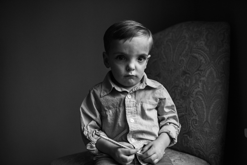 black and white photo of boy on dark background