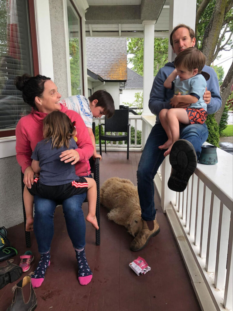 Family sitting on front porch of home