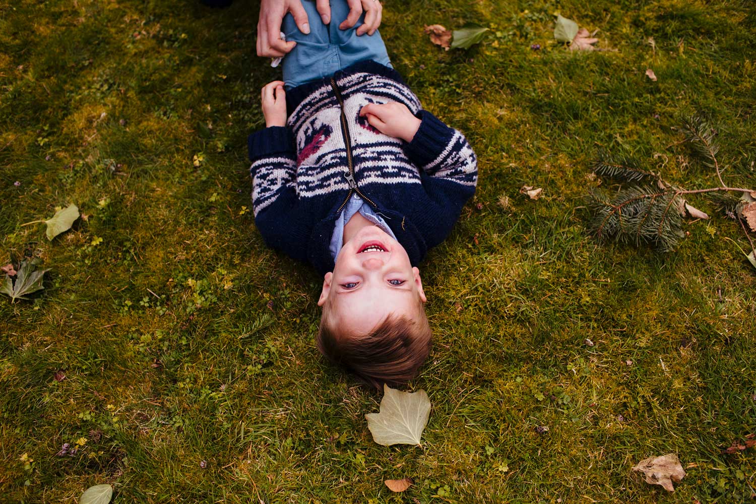 image of boy lying upside down on grass