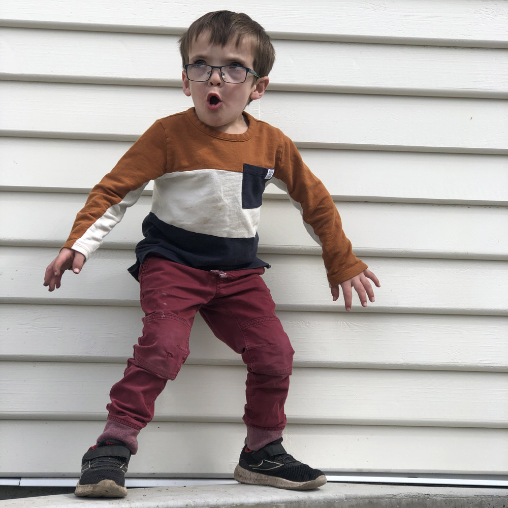 photo of boy standing in ready position looking excited